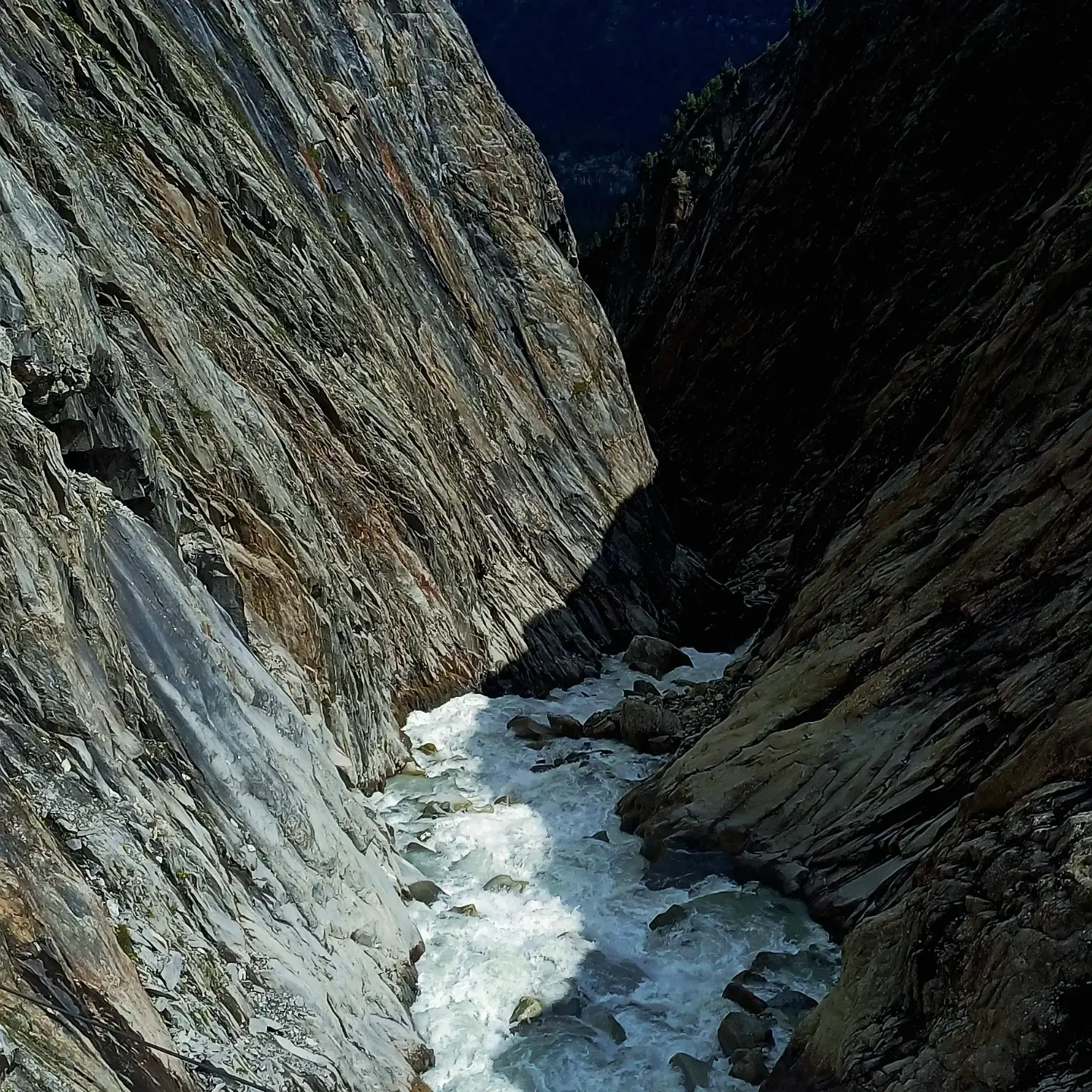 White water rushing through a narrow gorge between steep slabs of grey rock